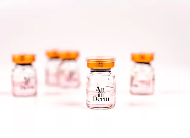 Lọ ALL IN DERM Solution Essence 3ml trên nền trắng, các lọ khác mờ phía sau